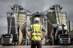 man stood in front of two lorries delivering waste